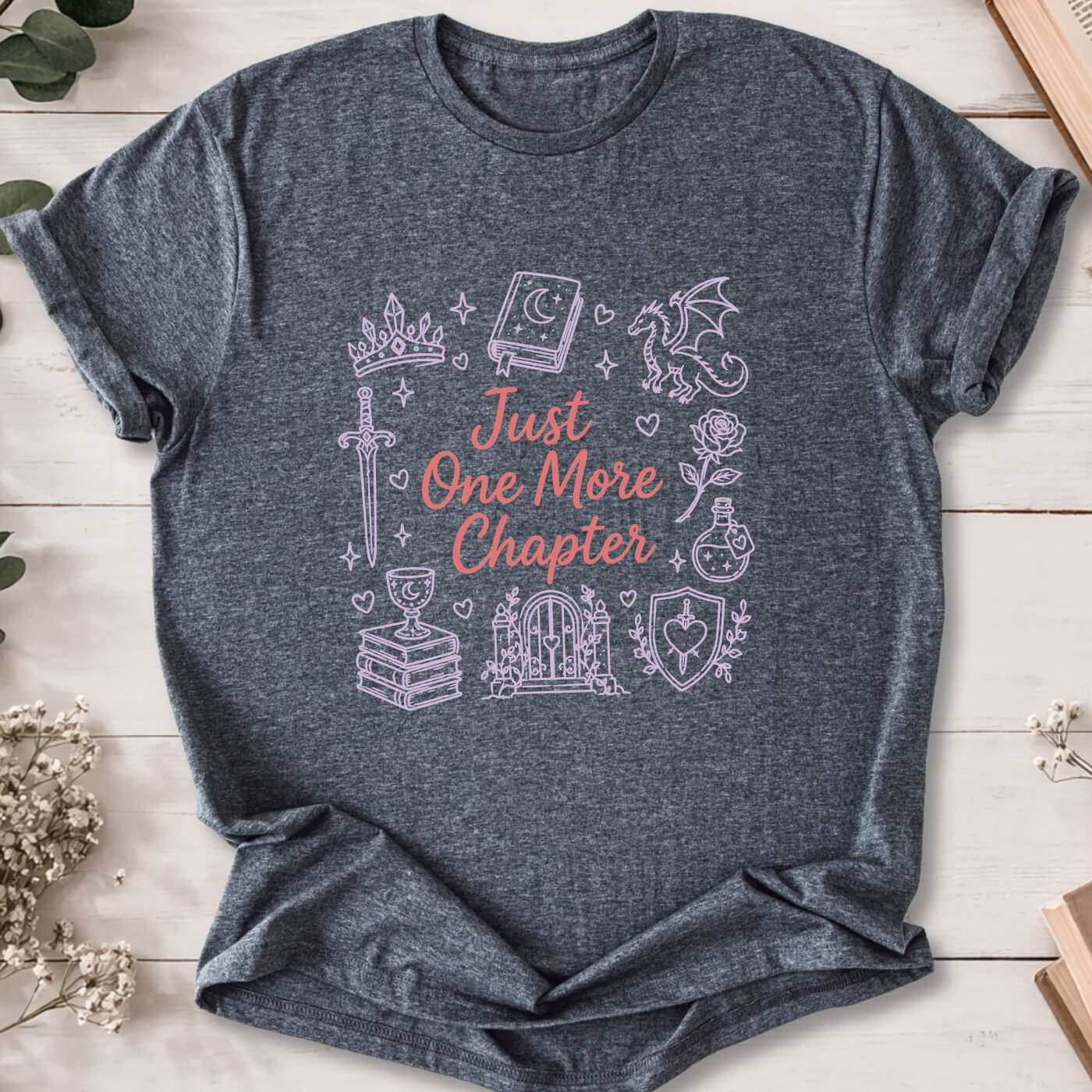 Just One More Chapter romantasy doodle t-shirt on dark heather grey Gildan 64000 with dragons, swords and fantasy icons.