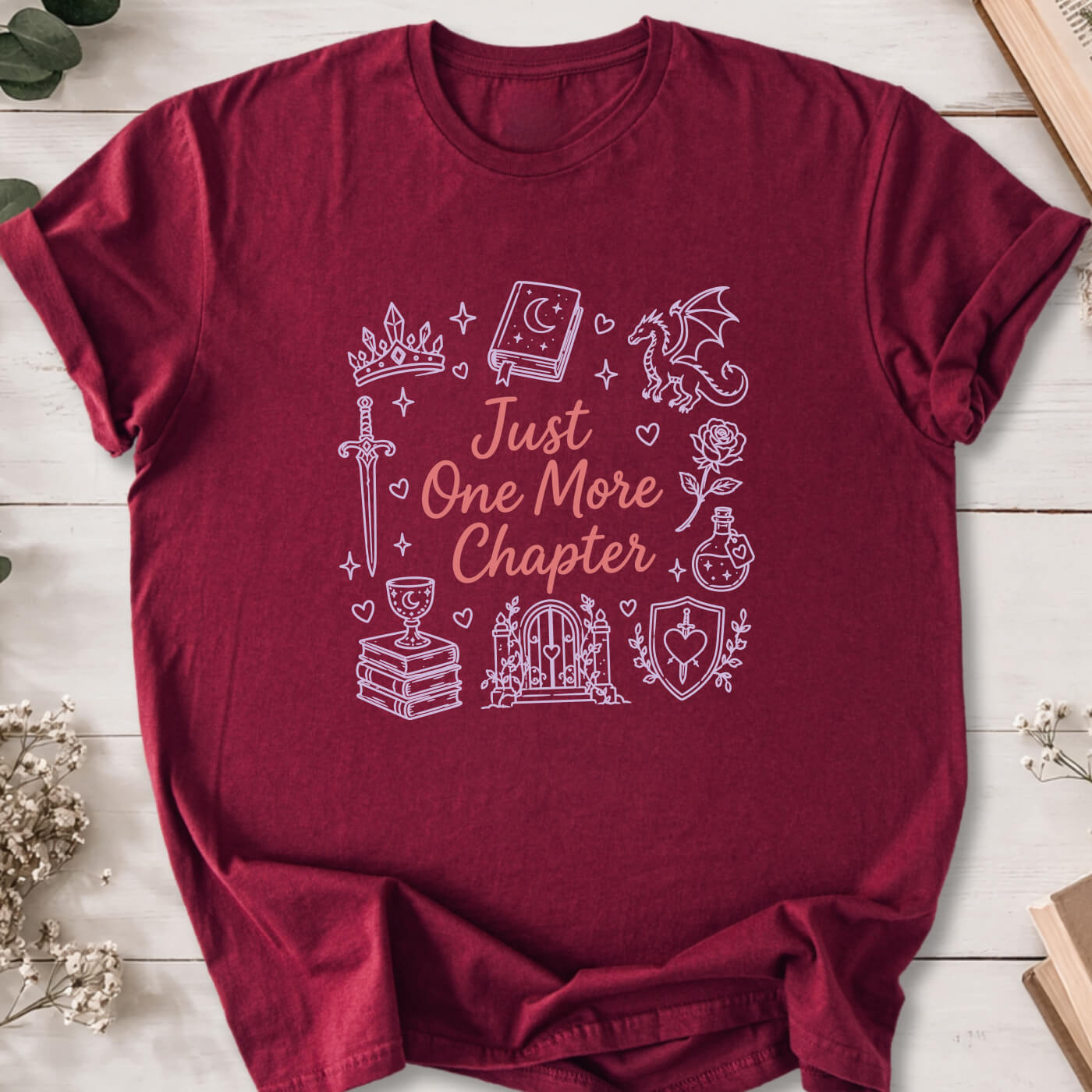 Just One More Chapter romantasy doodle t-shirt on marron Gildan 64000 with dragons, swords and fantasy icons.