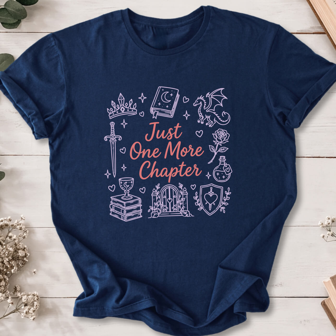 Just One More Chapter romantasy doodle t-shirt on navy Gildan 64000 with dragons, swords and fantasy icons.
